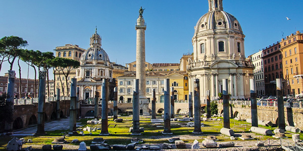 The columns of the Basilica Ulpia backed by Trajan's Column (and a pair of baroque church domes) in the Forum of Trajan, part of Rome's Imperial Fori